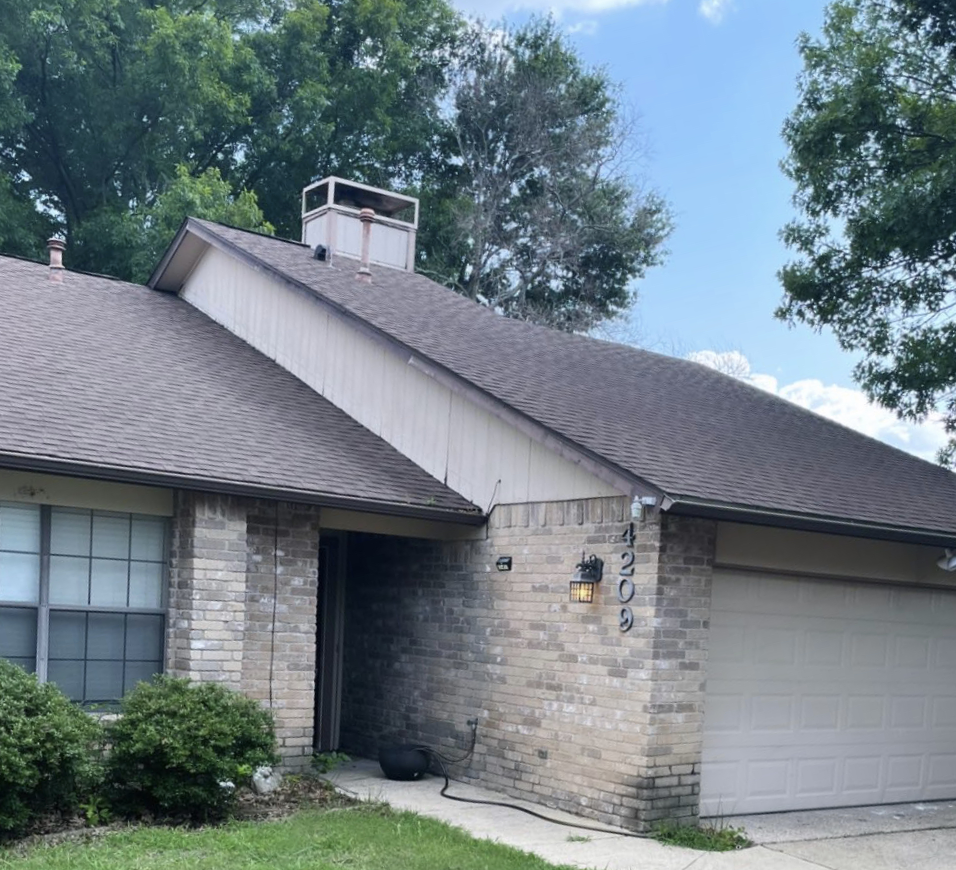 A single-story brick house with a brown shingle roof